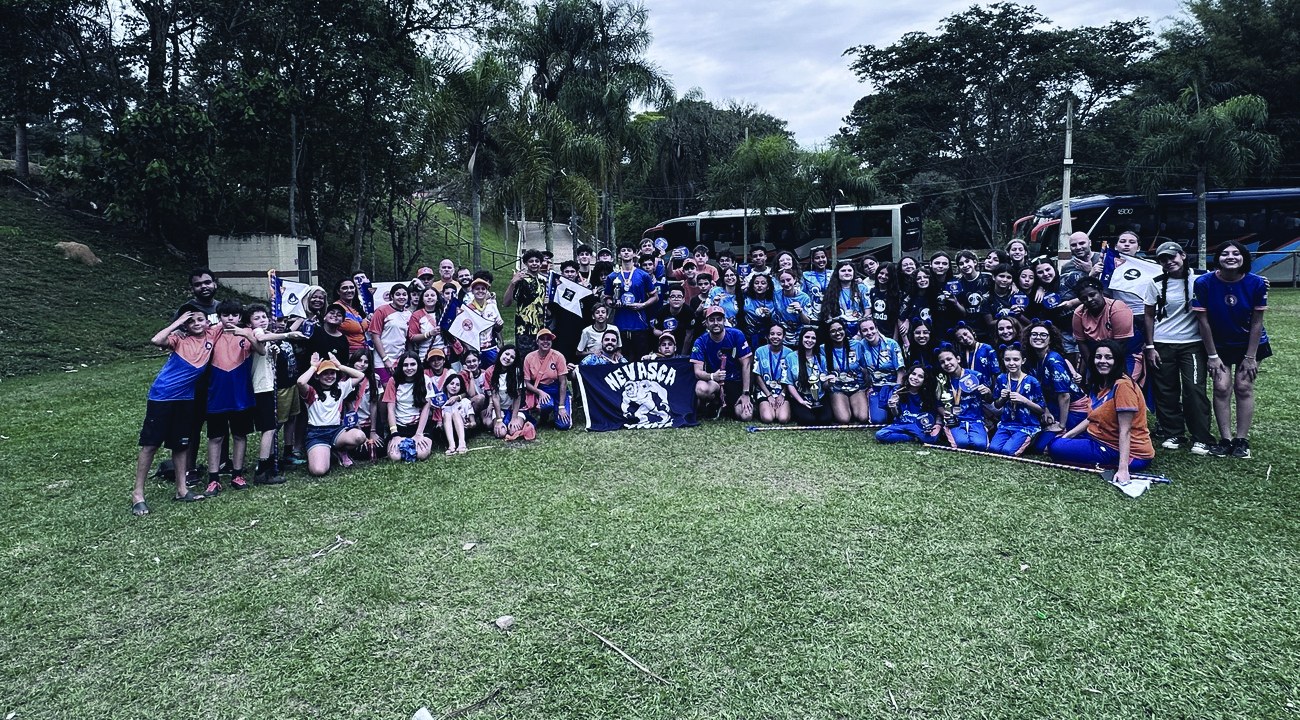 Desbravadores do Clube K2 reunidos com bandeiras e troféus
